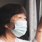 Masked Woman Looking Out the Window